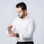 pexels-photo-28967487-28967487 Man in white shirt adjusting sleeve, showcasing elegance and style.